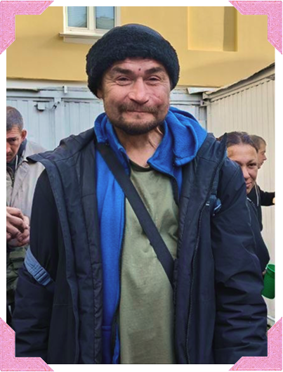Мужчина в чёрной вязаной шапке и синей куртке на вещевой выдаче